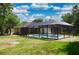 Backyard view of the screen enclosed pool and exterior of the home at 3405 Silver Glen Ct, Plant City, FL 33566