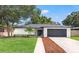 Charming single-story home with a well-manicured lawn and an attached two-car garage at 3408 W Swann Ave, Tampa, FL 33609