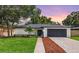 Charming single-story home with a well-manicured lawn and an attached two-car garage at 3408 W Swann Ave, Tampa, FL 33609