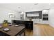 Modern kitchen features stainless steel appliances, a large island, and sleek white cabinetry and a dining table at 3408 W Swann Ave, Tampa, FL 33609