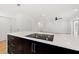 Kitchen island boasts sleek cooktop with quartz countertops and dark cabinetry at 3408 W Swann Ave, Tampa, FL 33609