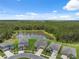 Aerial view of the neighborhood showcasing nearby homes, a serene pond, and scenic wooded area at 34797 Rainville Loop, Zephyrhills, FL 33541