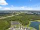 Expansive aerial view of a community featuring lush green spaces, tranquil ponds, and well-maintained homes under a bright blue sky at 34797 Rainville Loop, Zephyrhills, FL 33541