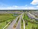 Community aerial view highlighting landscaped streets, a pond, and rows of single-Gathering homes under a bright blue sky at 34797 Rainville Loop, Zephyrhills, FL 33541