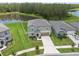 Beautiful aerial view of home showcasing the lawn and proximity to the community pond and lush greenery at 34797 Rainville Loop, Zephyrhills, FL 33541