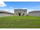 Large, grassy backyard featuring a fenced perimeter and the home's exterior at 34797 Rainville Loop, Zephyrhills, FL 33541