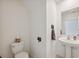 Well-lit half bathroom with a pedestal sink and neutral color palette at 34797 Rainville Loop, Zephyrhills, FL 33541
