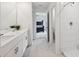 Bathroom featuring double sinks, white cabinets, and a shower at 34797 Rainville Loop, Zephyrhills, FL 33541
