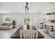 Open concept dining area flowing into a kitchen, with stylish light fixture and sliding glass door at 34797 Rainville Loop, Zephyrhills, FL 33541