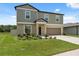 Well-maintained two-story home features a two-car garage, landscaped front yard, and lush green lawn at 34797 Rainville Loop, Zephyrhills, FL 33541