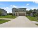 Inviting two-story home boasts a spacious driveway, two-car garage, and a meticulously kept front lawn at 34797 Rainville Loop, Zephyrhills, FL 33541