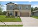 Charming two-story home features a two-car garage and a well-manicured lawn with tasteful landscaping at 34797 Rainville Loop, Zephyrhills, FL 33541