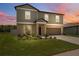 Two-story home with a two-car garage, neat landscaping, and beautiful hues as dusk settles at 34797 Rainville Loop, Zephyrhills, FL 33541