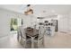 Dining area with modern lighting leading to a kitchen with stainless steel appliances at 34797 Rainville Loop, Zephyrhills, FL 33541