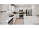 Bright kitchen features stainless steel appliances, light wood flooring, white cabinets, and a large island with bar stool seating at 34797 Rainville Loop, Zephyrhills, FL 33541