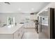 Bright kitchen features stainless steel appliances, light wood flooring, white cabinets, and a large island with bar stool seating at 34797 Rainville Loop, Zephyrhills, FL 33541