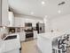Bright kitchen features stainless steel appliances, light wood flooring, white cabinets, and a large island with bar stool seating at 34797 Rainville Loop, Zephyrhills, FL 33541