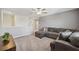 Upstairs living room featuring a ceiling fan, comfortable gray sectional sofa, and a dark wood entertainment center at 34797 Rainville Loop, Zephyrhills, FL 33541