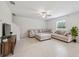 Well-lit living room with tile flooring, sectional sofa, and a decorative media console at 34797 Rainville Loop, Zephyrhills, FL 33541