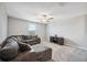 Upstairs living room featuring a ceiling fan, comfortable gray sectional sofa, and a dark wood entertainment center at 34797 Rainville Loop, Zephyrhills, FL 33541