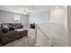 Upstairs living room featuring a ceiling fan, comfortable gray sectional sofa, and a dark wood entertainment center at 34797 Rainville Loop, Zephyrhills, FL 33541