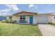 Charming single-story home with a well-manicured front yard and bright blue door at 3818 Beechwood Dr, Holiday, FL 34691