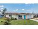 Charming single-story home with a well-manicured front yard and bright blue door at 3818 Beechwood Dr, Holiday, FL 34691