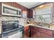 This kitchen boasts sleek dark cabinets, granite countertops, and stainless steel appliances at 3818 Beechwood Dr, Holiday, FL 34691
