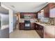 Spacious kitchen featuring stainless steel appliances, granite countertops, and tile flooring at 3818 Beechwood Dr, Holiday, FL 34691