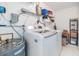 Laundry area features a modern washer and dryer, storage shelves, and a water heater at 3818 Beechwood Dr, Holiday, FL 34691