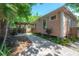 Charming backyard featuring a brick pathway, lush landscaping, and a covered outdoor dining area at 409 E Frances Ave, Tampa, FL 33602