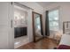 Bedroom with hardwood flooring, large mirror, and an ensuite bathroom with a sliding barn door at 409 E Frances Ave, Tampa, FL 33602
