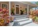 Inviting front porch with stylish planters, decorative potted foliage, and a stately, paneled front door at 409 E Frances Ave, Tampa, FL 33602