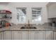 Kitchen sink beneath dual windows with a granite counter top and tiled backsplash at 409 E Frances Ave, Tampa, FL 33602