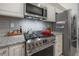 Close-up of a stainless steel oven and hood, granite counters, and white subway tile backsplash at 409 E Frances Ave, Tampa, FL 33602