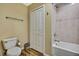 Well-lit bathroom features wood-look flooring, toilet, shower, and bi-fold door closet at 4123 Daisy Dr, Hernando Beach, FL 34607