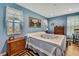 Cozy bedroom featuring blue walls, wood flooring, and well-decorated dressers and windows at 4123 Daisy Dr, Hernando Beach, FL 34607