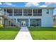 Home exterior with a covered patio below a screened in deck, complemented by lush lawn and outdoor seating at 4123 Daisy Dr, Hernando Beach, FL 34607