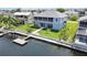 Lovely waterfront home boasts a private dock, green lawn, mature landscaping, and a screened upper porch at 4123 Daisy Dr, Hernando Beach, FL 34607