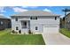 Inviting two-story home with a manicured lawn, showcasing its welcoming entrance and attached garage at 4123 Daisy Dr, Hernando Beach, FL 34607