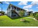 Two-story home with a screened deck, backyard lawn and stairs to the ground level at 4123 Daisy Dr, Hernando Beach, FL 34607