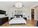 Bright bedroom featuring hardwood floors, modern light fixture, and ensuite walk-in closet at 443 Lucerne Ave, Tampa, FL 33606