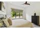 Bright bedroom featuring a ceiling fan, large window with backyard view, and minimalist decor at 443 Lucerne Ave, Tampa, FL 33606