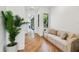 Bright hallway features wood floors, a comfortable sofa, and natural light from nearby windows at 443 Lucerne Ave, Tampa, FL 33606