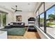 Bright living room featuring hardwood floors, large windows, a comfortable sofa, and exercise equipment at 443 Lucerne Ave, Tampa, FL 33606