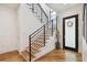 Modern staircase with wood treads, black railing, and glass door at 443 Lucerne Ave, Tampa, FL 33606