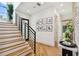 Modern staircase with hardwood steps, black metal railing, and large windows providing natural light at 443 Lucerne Ave, Tampa, FL 33606