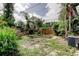 Expansive grassy backyard surrounded by lush greenery and a wooden fence at 4479 Newark N St, St Petersburg, FL 33714