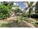 Spacious backyard featuring green grass, garden with lush plants, and fruit trees at 4479 Newark N St, St Petersburg, FL 33714