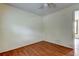 View of the bedroom with wood flooring, white walls, window, and ceiling fan at 4479 Newark N St, St Petersburg, FL 33714